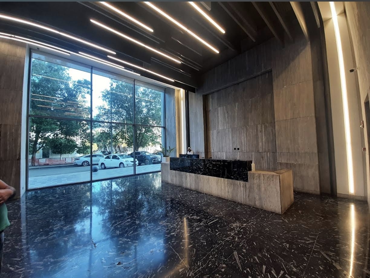 Main building lobby at Quartz Centre, with large windows, stone finishes and a reception counter.